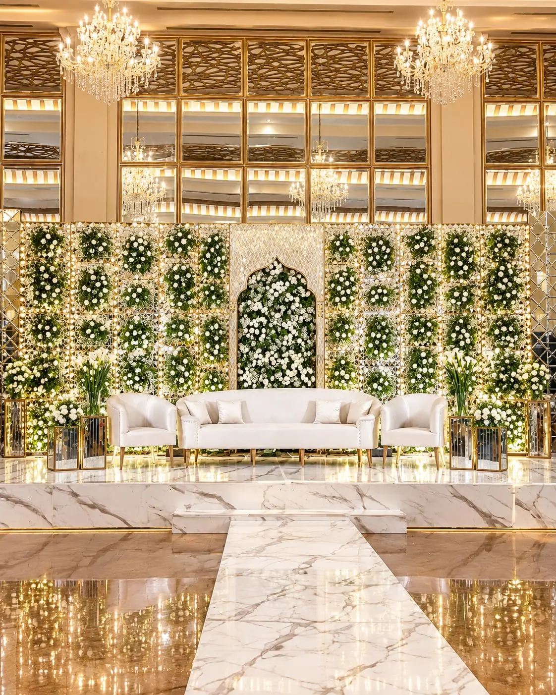 Two cream sofas on a marble aisle before a white and green floral screen