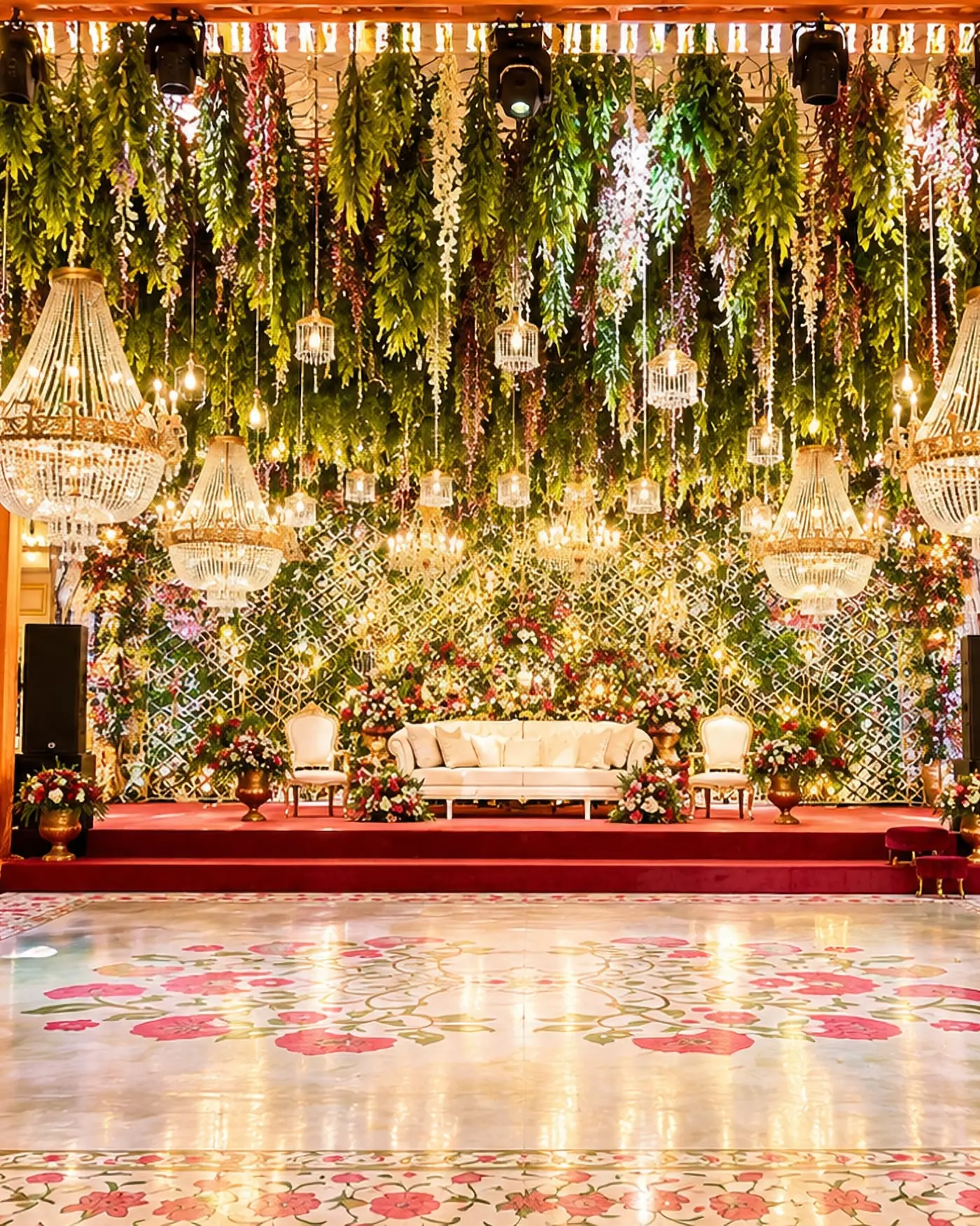 A wedding stage beneath a hanging floral ceiling, with a mirrored dance floor before it