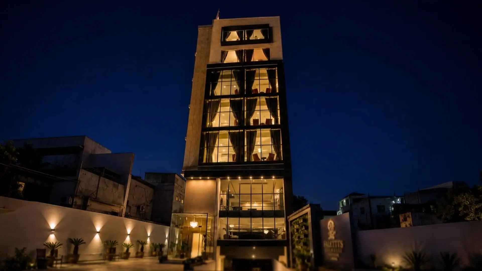 Faletti’s Grand Gulberg at night, a narrow glass tower lit from within