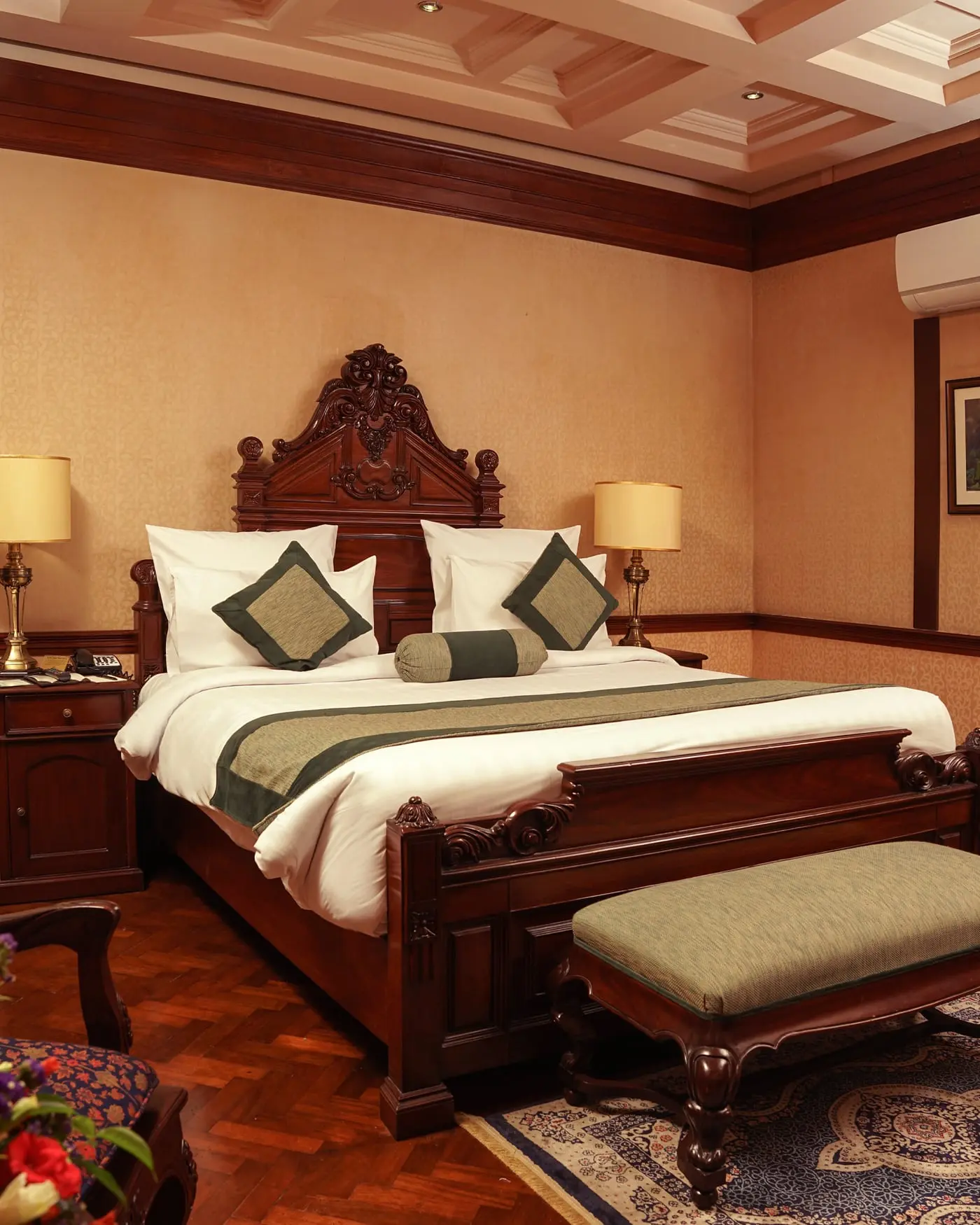 Bedroom with a carved wooden bed and parquet floor