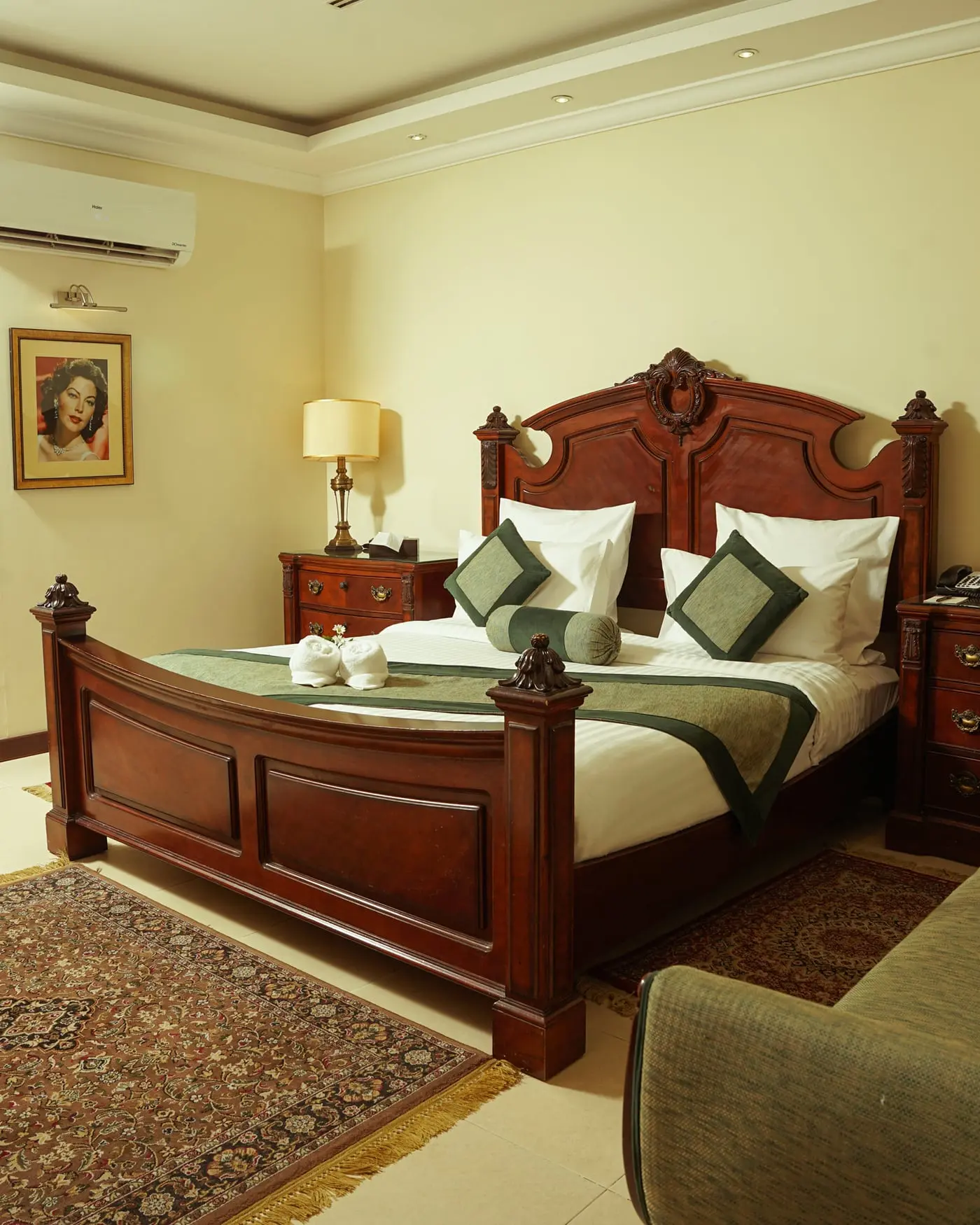 Bedroom with a carved bed and a framed portrait