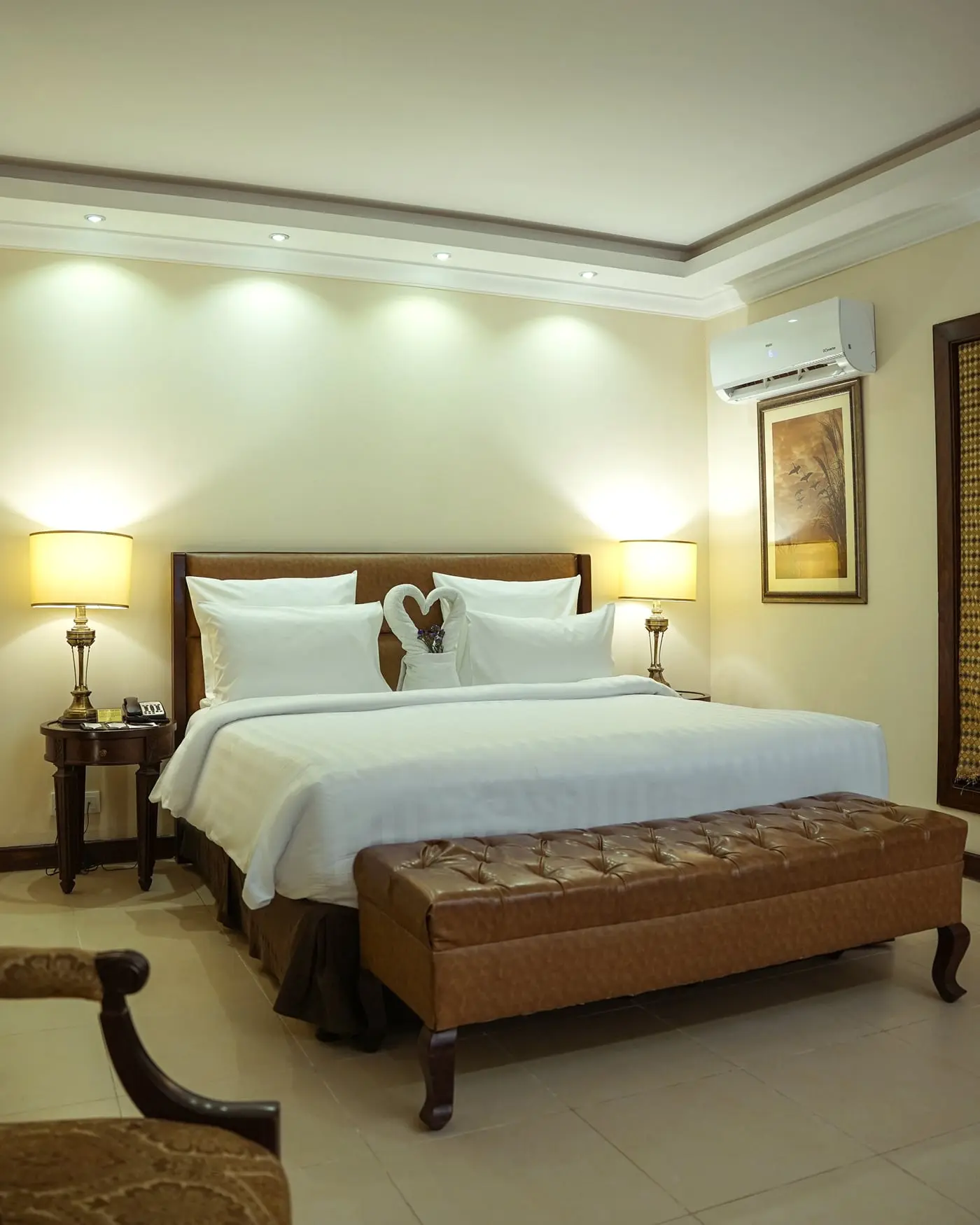 Bedroom with white linen and an upholstered bench