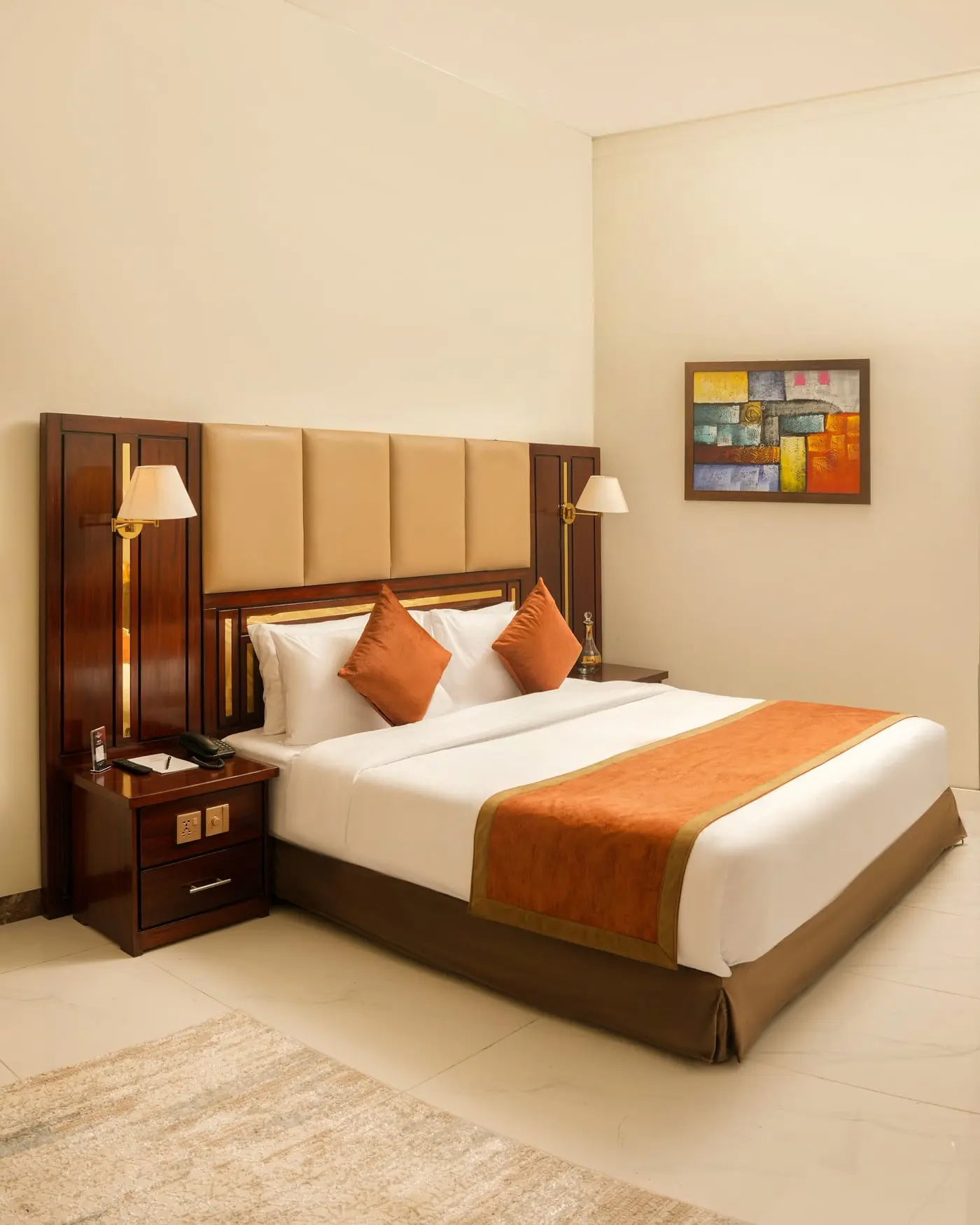 A king bed and walnut headboard at Faletti’s Residences Top City