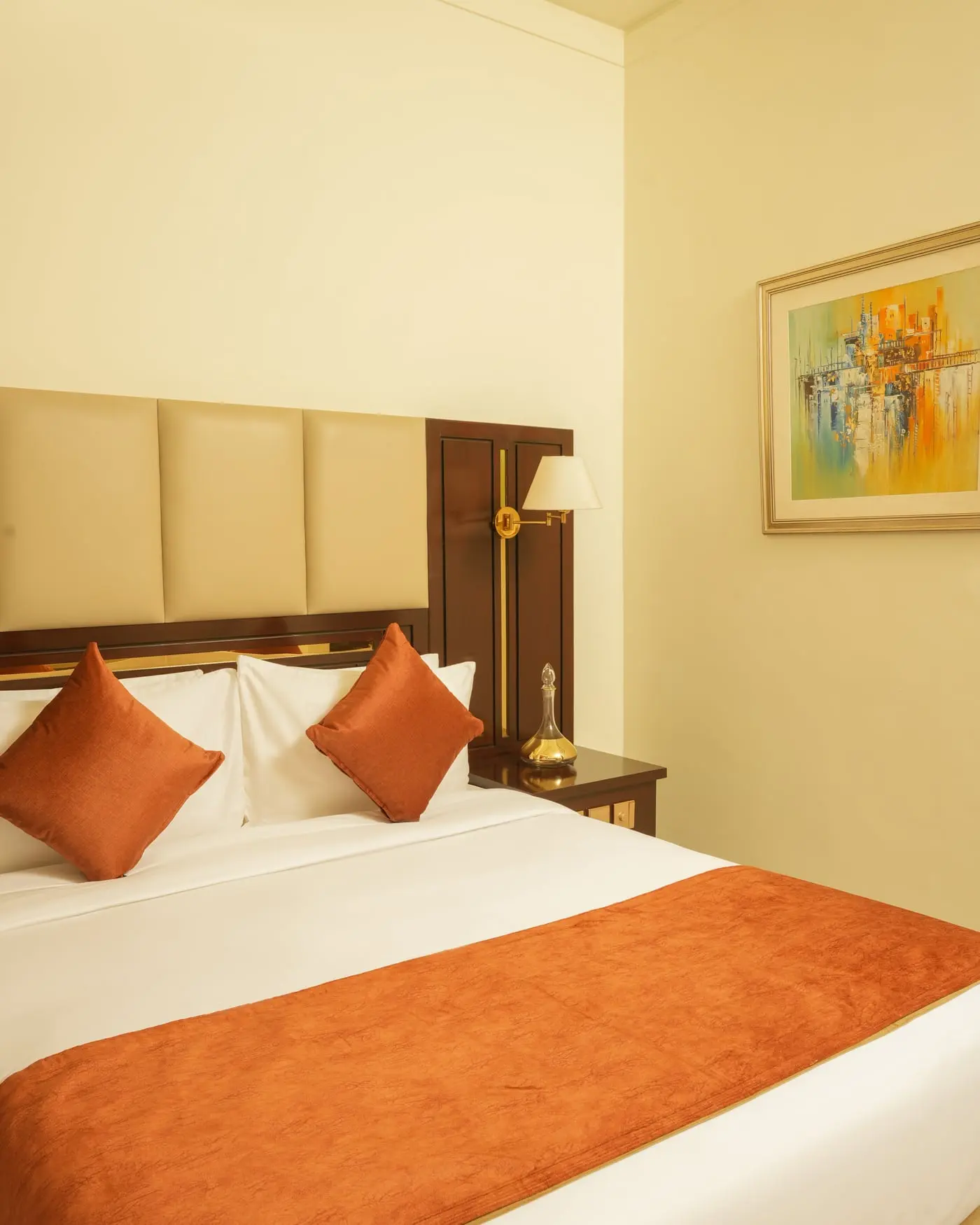 A king bed below framed artwork at Faletti’s Residences Top City