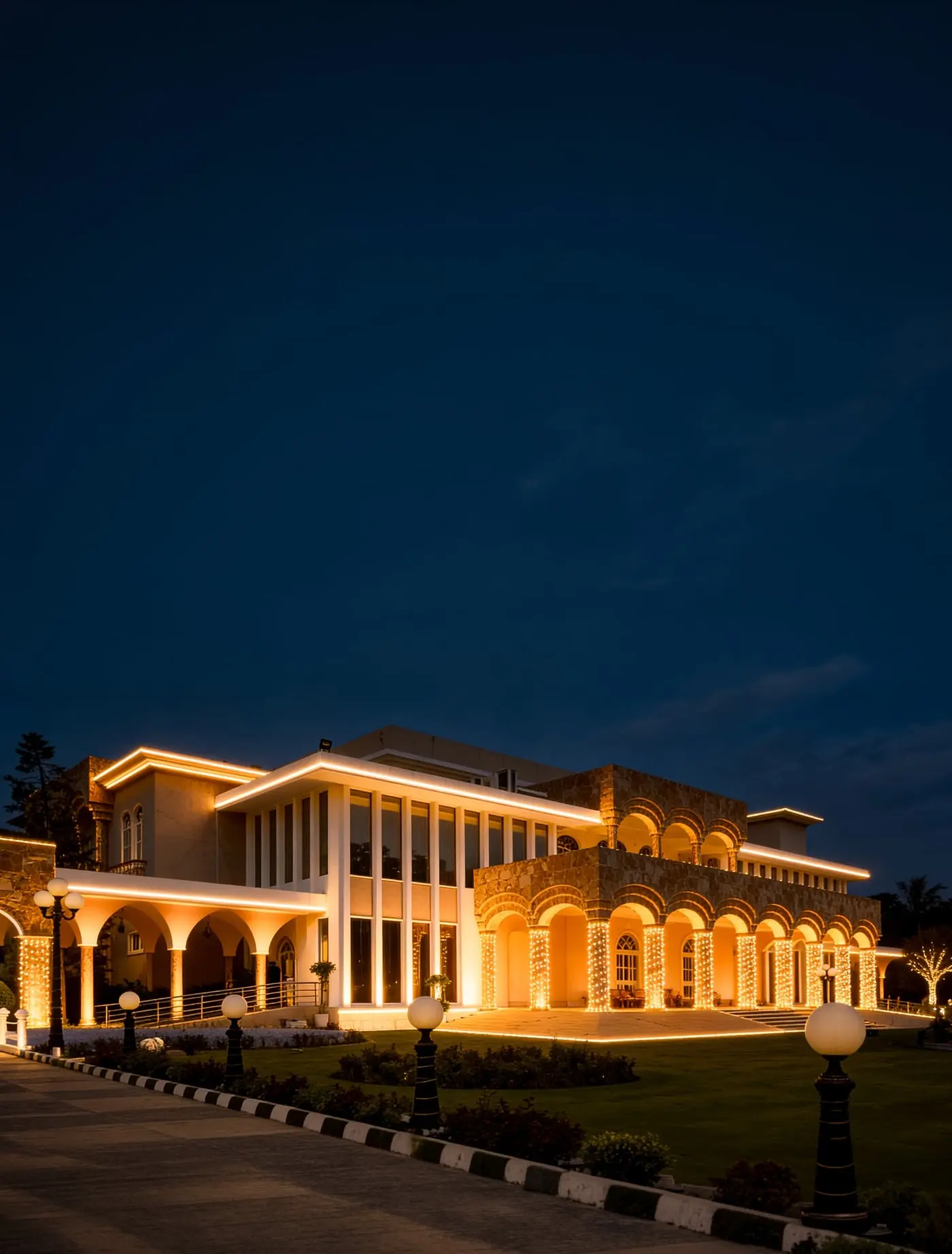 The Palace Banquet floodlit at dusk beyond its lawn